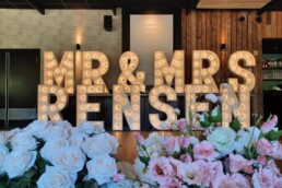 LICHTLETTERS VOOR EEN BRUILOFT MET BLOEMEN OP DE VOORGROND