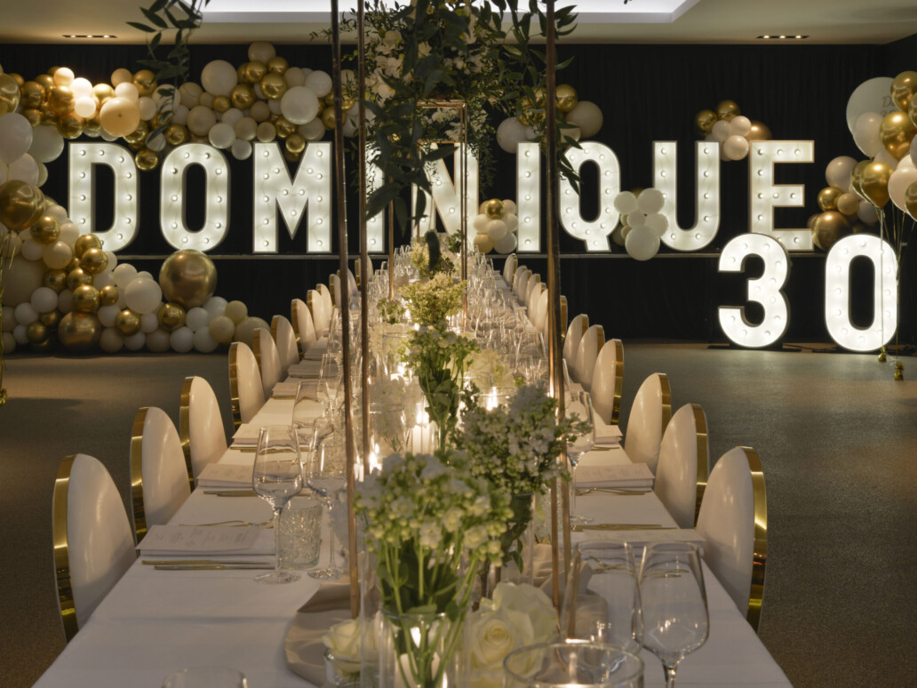 OPGEDEKTE TAFEL VOOR EEN PRIVATE DINNER MET OP DE ACHTERGROND LICHTLETTERS